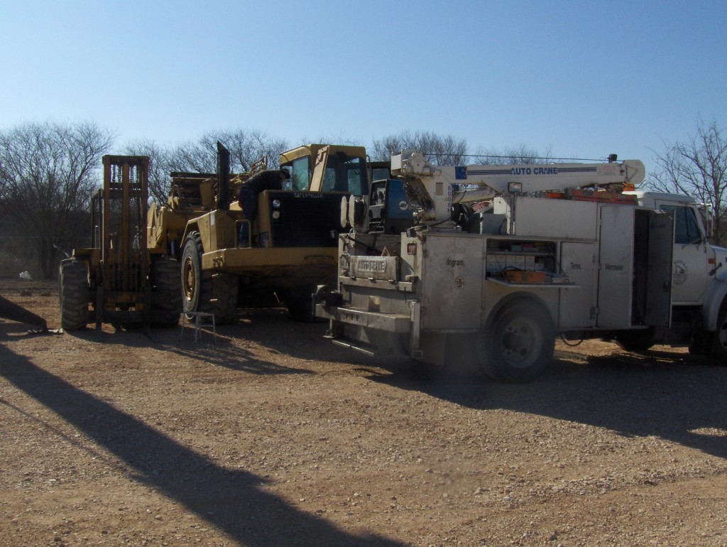 Mechanic fixing a dump truck and fork lift