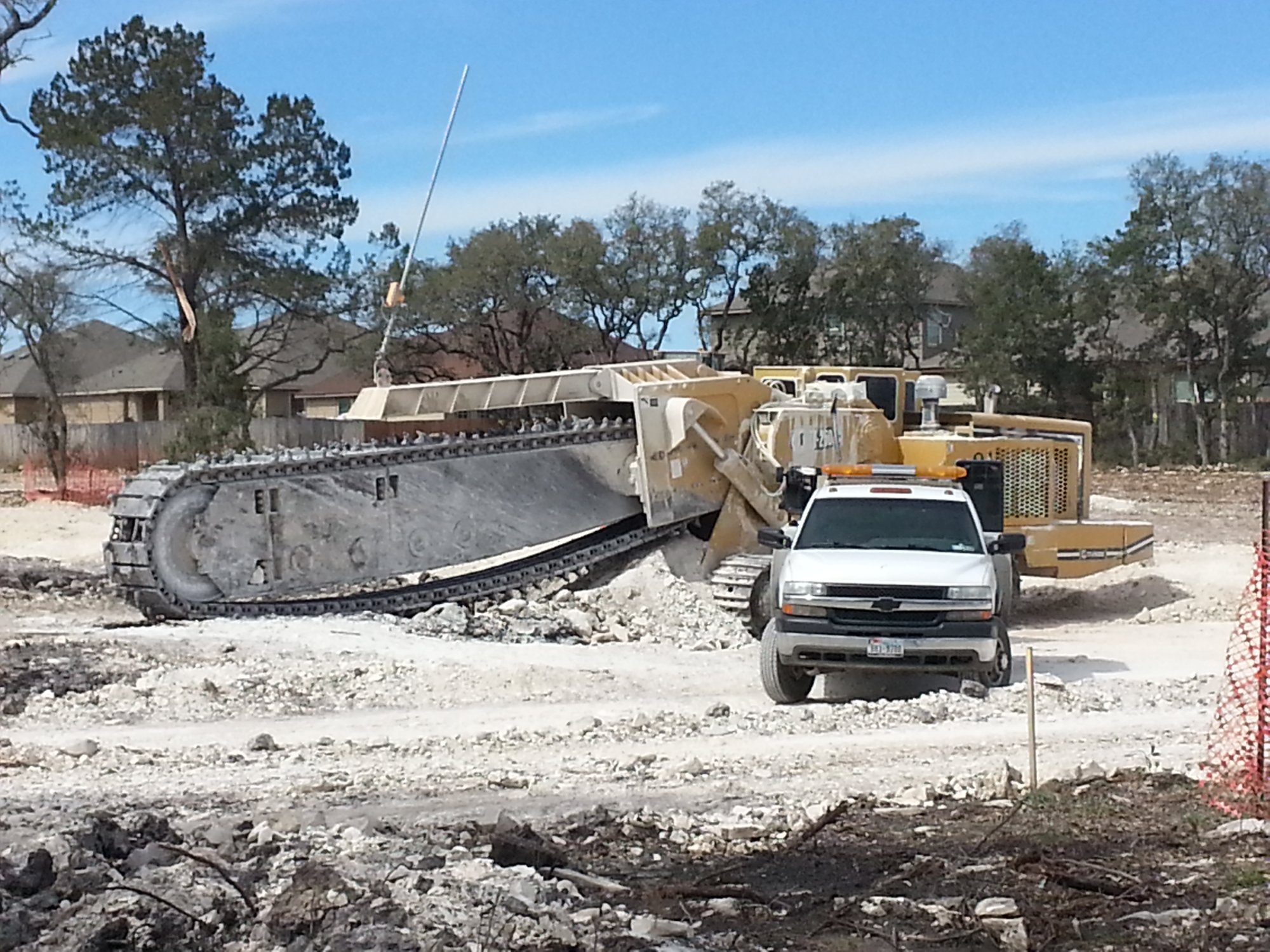 Large chain trencher heavy equipment repair with A.L. Boeck and Co. service truck on San Antonio Texas job site